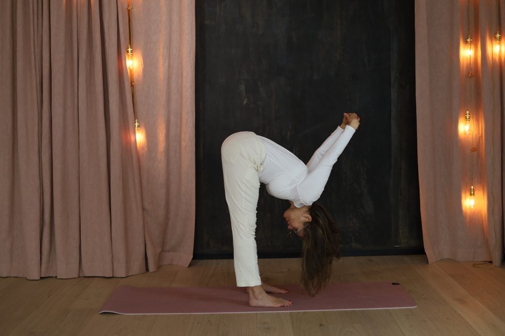 Eva Aminoff in a yoga pose head against her knee